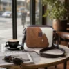 Large cowhide crossbody bag in black brown and orange with box style shape, leather finish, long strap, main compartment and inside pocket