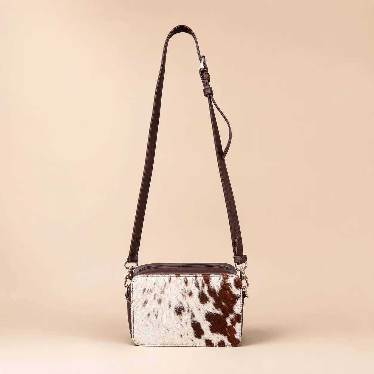 Large cowhide crossbody bag in black brown and orange with box style shape, leather finish, long strap, main compartment and inside pocket