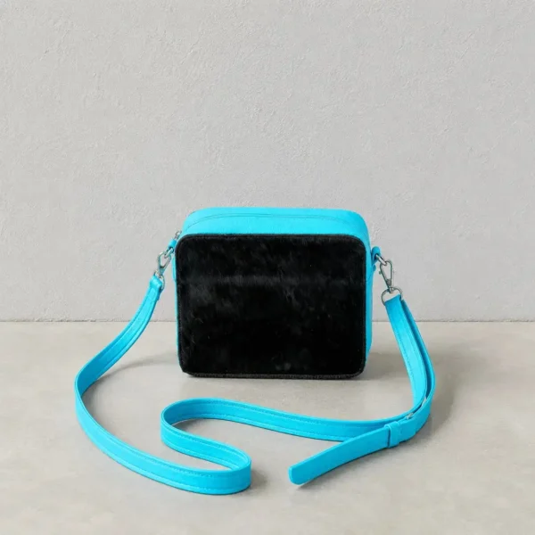 Leather cowhide box style crossbody bag with turquoise strap, brown and white cowhide texture, structured purse design and adjustable shoulder strap