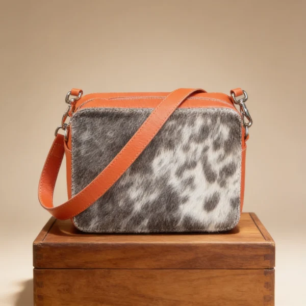 Orange cowhide crossbody bag with box style shape, cow finish leather, long strap, large compartment and inside pocket