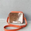 Orange cowhide crossbody bag with box style shape, cow finish leather, long strap, large compartment and inside pocket