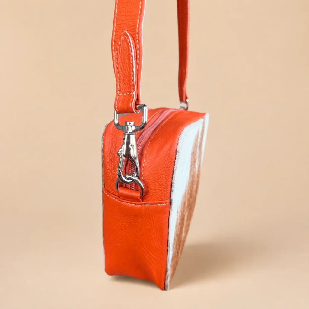 Orange cowhide crossbody bag with box style shape, cow finish leather, long strap, large compartment and inside pocket
