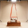 Orange cowhide crossbody bag with box style shape, cow finish leather, long strap, large compartment and inside pocket