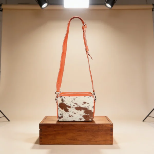 Orange cowhide crossbody bag with box style shape, cow finish leather, long strap, large compartment and inside pocket