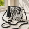 Black and white cowhide mobile phone pouch square style with zipper pocket, cow finished leather strap and adjustable shoulder bag design
