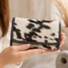 Black and white cowhide flip wallet for women with magnetic cover and multiple card compartments