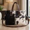 Cowhide mini duffel bag in black and brown with shoulder strap