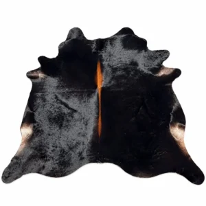 Brazilian cowhide rug in black with brown spine made from genuine cowhide shown on a white background