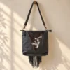 Black cowhide crossbody purse with hand tooled bull head patch