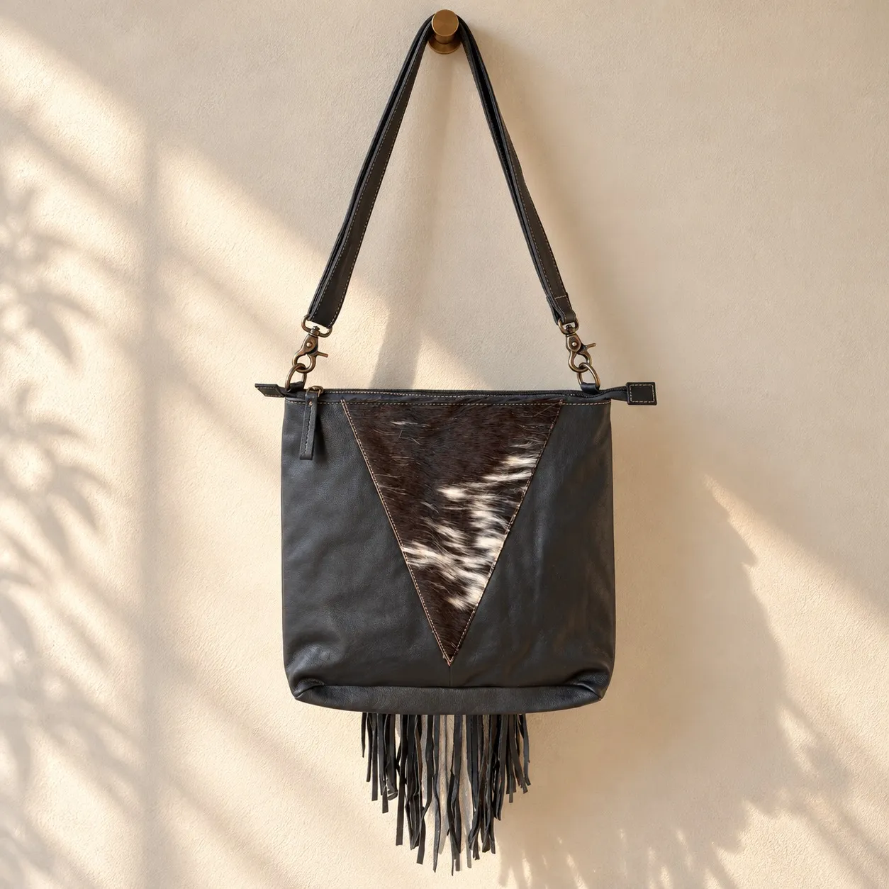 Black cowhide crossbody purse with hand tooled bull head patch
