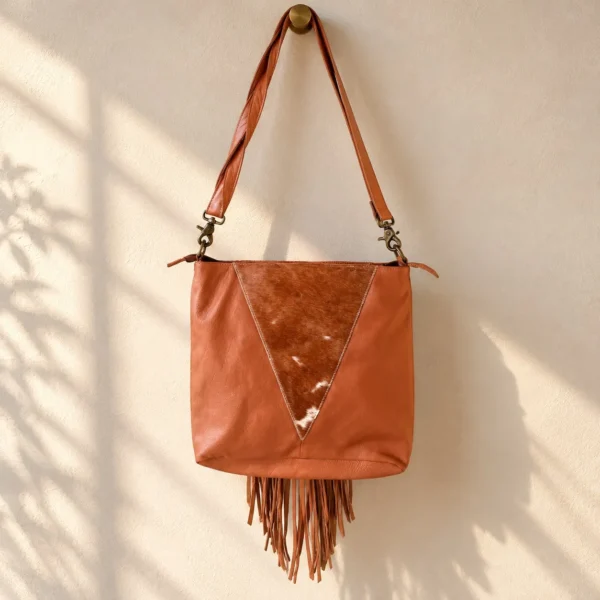 Cowhide crossbody purse hanging with adjustable strap and fringe