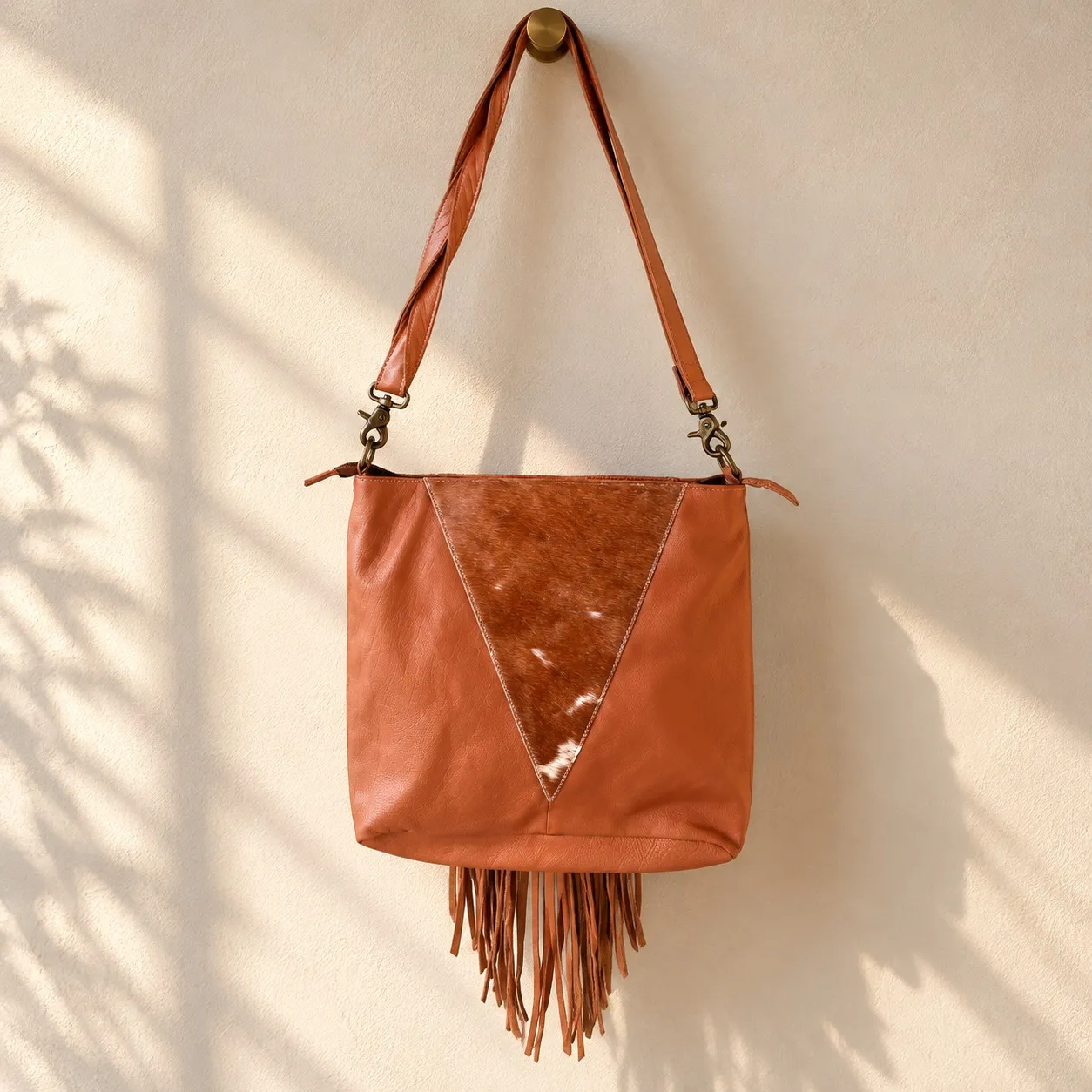 Cowhide crossbody purse hanging with adjustable strap and fringe